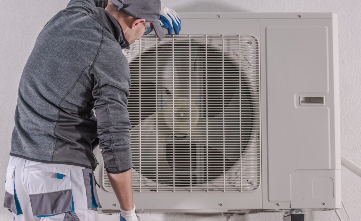 Réparation moderne de la pompe à chaleur par le technicien en race blanche dans la trentaine.